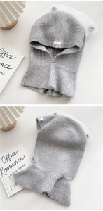 Close-up of grey knitted hooded scarf featuring fine ribbed texture and white logo label