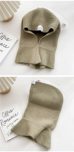 Detailed knit texture of olive green balaclava with decorative label and ribbed pattern