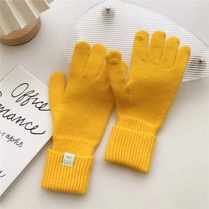 Detail of yellow knit gloves with ribbed cuffs and touchscreen finger openings