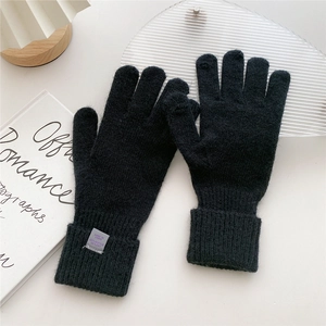 Detail of black knit gloves with ribbed cuffs showing the 70% acrylic material texture