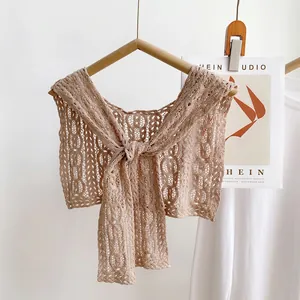 Detailed close-up of lace crochet hollow shawl with floral pattern and front ribbon tie
