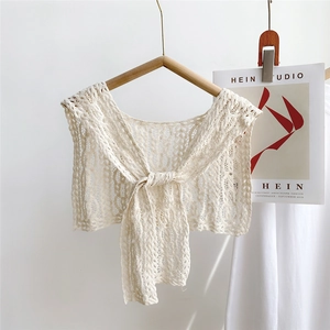 Close-up of white lace crochet hollow-out shawl with elegant tie ribbons