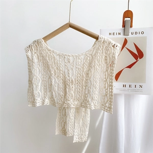 Detailed macro view of the vintage hollow-out knitted lace shawl in cream white finish