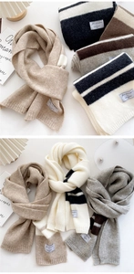 Close-up of thick knit striped scarf texture with soft warm fabric and woven label