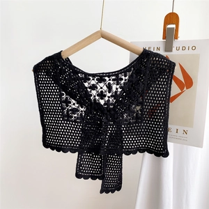 Detailed close-up of a black hollow crochet lace faux collar with floral knit patterns
