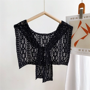 Close-up of black hollow crochet lace shawl with geometric floral knit patterns