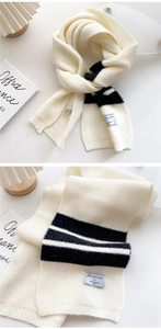 Detail of soft black and white striped knit scarf showing high-density texture and brand label