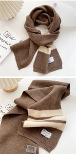 Detailed close-up of brown striped knit scarf texture with a white decorative brand tag
