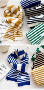 Detail view of colorful striped knit scarves with white decorative labels in various colors