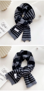 Detailed texture of black and grey striped knit scarf on aesthetic home decor background