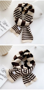 Detailed knit texture and ribbed edges of a thick brown and cream striped scarf