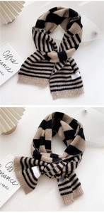 Detail view of a thick knitted striped scarf in beige and black with rib-knit edge finishing