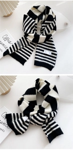 Close-up of black and white striped knit scarf showing soft texture and woven label