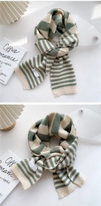 Detail of green and white striped knit scarf showing soft texture and ribbed edges