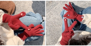 Detail of red cable knit gloves with open fingertips for easy touchscreen phone usage