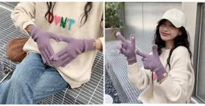 Detail of purple knit gloves featuring two-finger touchscreen openings and square wrist tag