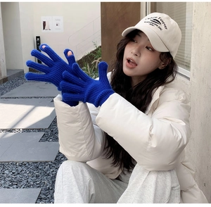 Detail of royal blue thick knit gloves with two-finger touchscreen opening for winter