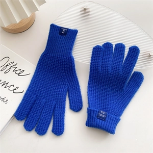 Detail of royal blue waffle knit gloves showing texture and material composition tag
