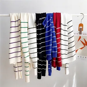 Striped knitted shawl shrugs in multiple colors including navy, red, and green stripes
