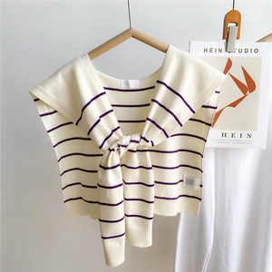 Detail of knitted cream shawl with purple stripes and front tie-knot design