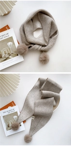 Détail de l'écharpe en maille côtelée beige avec texture douce et pompons soyeux