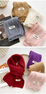Detail of cable knit scarves in various colors with YYDS logo patch detail