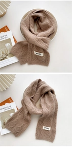 Close-up of cable knit texture on a latte brown winter scarf with stylish patch detail