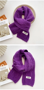 Detail of purple knit scarf showing diamond cable stitch pattern and YYDS woven label