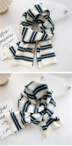 Detail of striped knit scarf with leather patch showing soft texture and premium weave