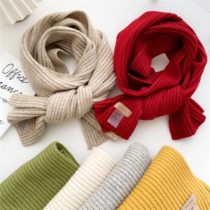 Detailed close-up of ribbed knit texture and premium leather labels on colorful scarves