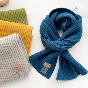 Chunky knit scarves in blue, gray, yellow, and green colors with ribbed texture