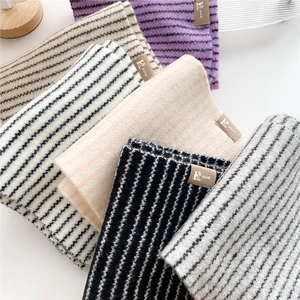 Striped knitted scarf for women in multiple colors with leather logo patch detail