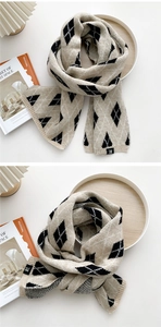 Detail eines Strickschals mit Rautenmuster in Schwarz-Beige und kleinem H-Logo-Label