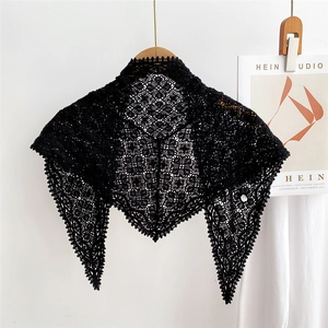Close-up of black knitted lace triangle scarf featuring intricate hollow-out geometric patterns