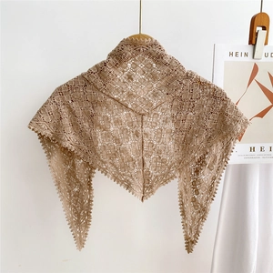 Detail of beige crochet triangle scarf featuring openwork floral knit and lace edges