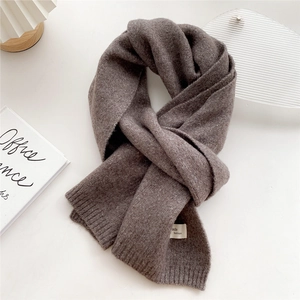 Close-up of deep coffee knit scarf with fine texture and branded fashion label