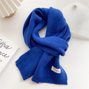 Detailed knit texture of solid deep blue wool scarf with a handmade fashion label