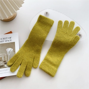 Close-up of mustard green knitted gloves showing thick warm texture and ribbed cuffs