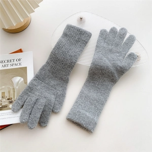 Close-up of gray knitted gloves with fluffy texture and extended cuffs for winter warmth