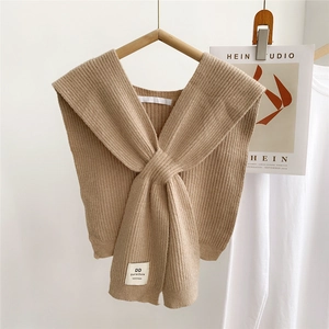 Close-up of camel knitted shawl with vertical ribbed texture and handmade woven label