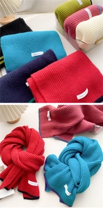 Detailed view of colorful thick knit scarves with ribbed texture and woven brand labels