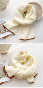 Macro view of thick knit scarf with vertical stripes and brown scalloped trim edges