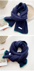 Detail of navy knit scarf with green hem and VANEELVINES brand label texture