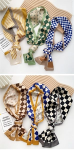 Detail showing assorted silk twilly scarves with striped and checkered patterns on wood