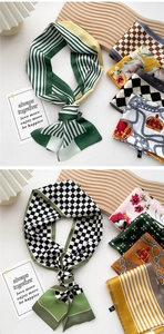 Detail view of various patterned silk scarves with stripes and floral prints on wood décor