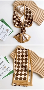 Detail of checkered narrow silk scarf with letter R pattern and 100% polyester satin texture