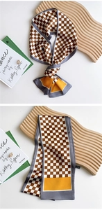 Detail of checkered brown silk scarf showing 100% polyester fabric and wave wooden board