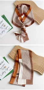 Detail of striped narrow silk scarf with geometric pattern and smooth satin texture