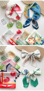 Flat lay of colorful 70cm square silk scarves featuring fruit and floral art patterns