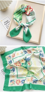 Detail of elegant green floral silk scarf showing premium fabric texture and hand-painted art